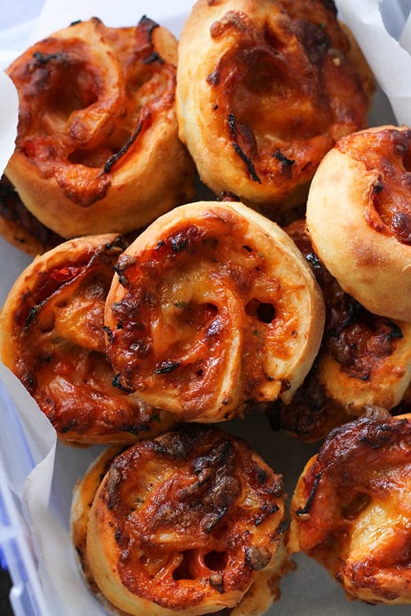 pizza scrolls piled on top of each other in a container.