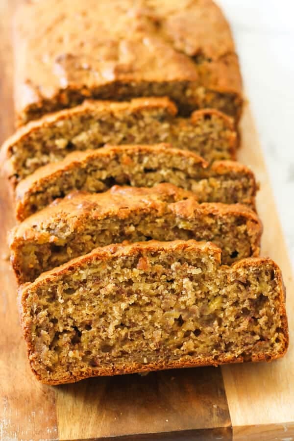 Sliced buttermilk banana bread laying on a wooden board.