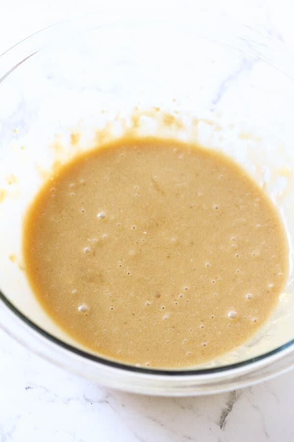 banana bread ingredients mixed in a glass bowl. 