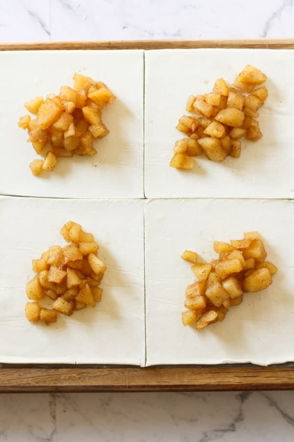 puff pastry cut into squares with spoonfuls of diced apple in the centre.