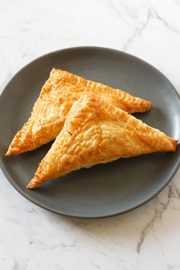 two apple turnovers on a grey plate.