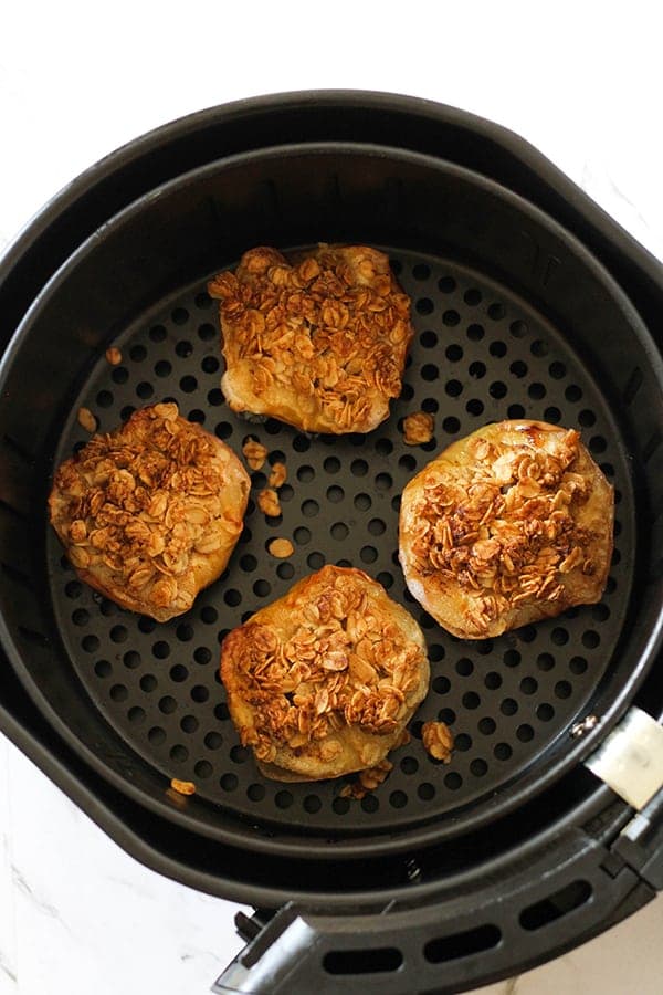 cooked baked apples in an air fryer basket.