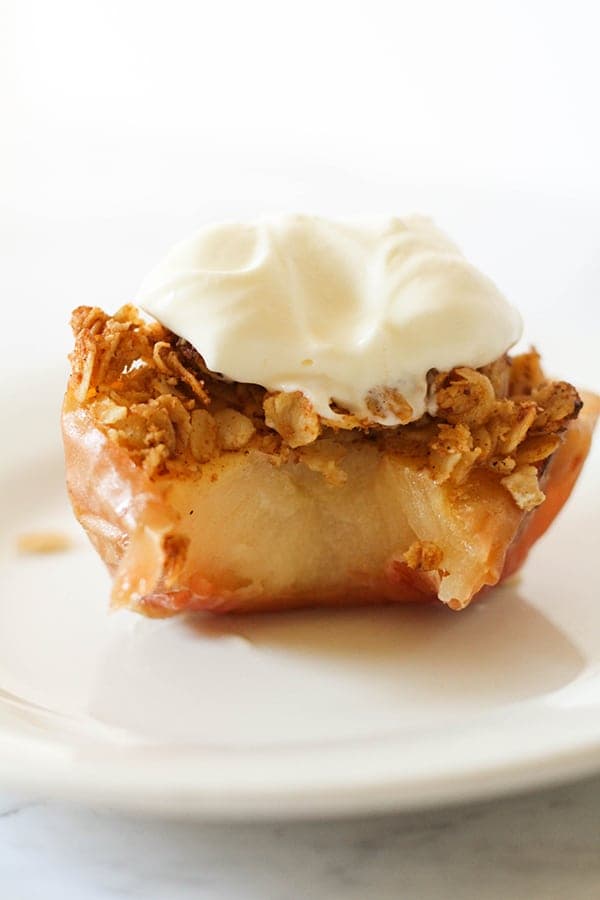 baked apple topped with ice cream on a white plate.