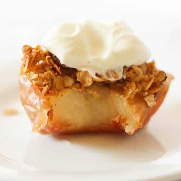 baked apple topped with ice cream on a white plate.