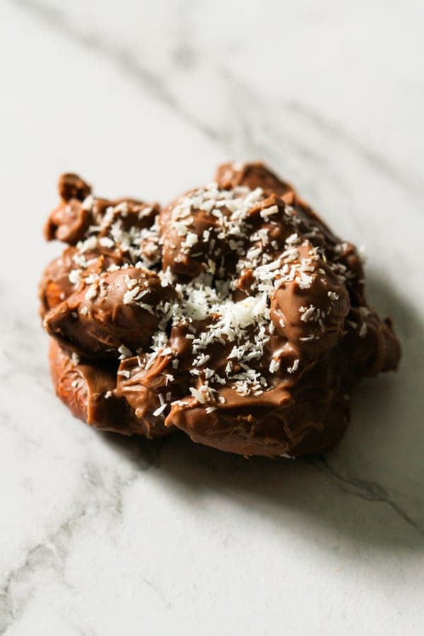 a chocolate covered almond cluster on a marble background