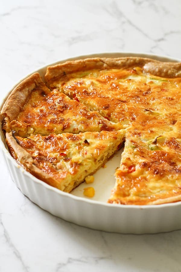 vegetarian quiche in a white quiche dish.