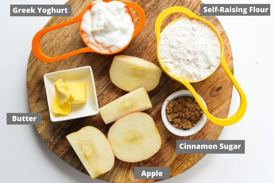 air fryer apple cinnamon roll ingredients on a wooden board.