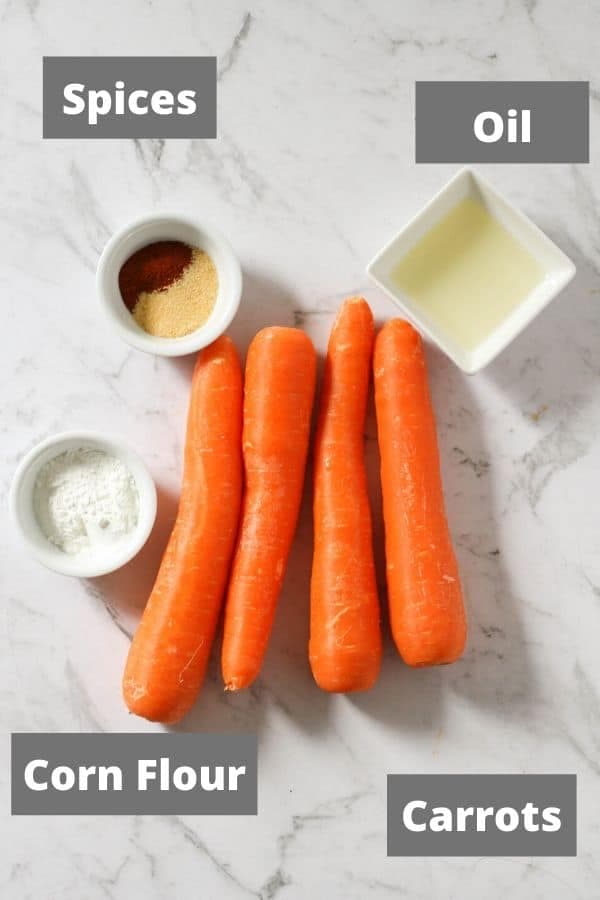 ingredients for air fryer carrot fries on a white marble background.