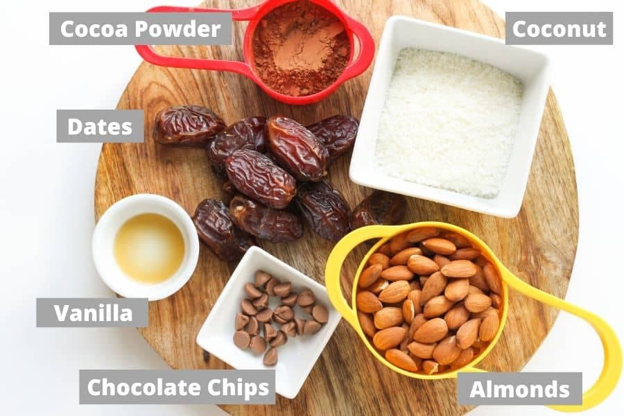 ingredients to make chocolate coconut energy balls on a wooden board.