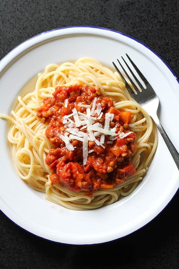 lentil bolognese on top of spaghetti with shaved parmesan.
