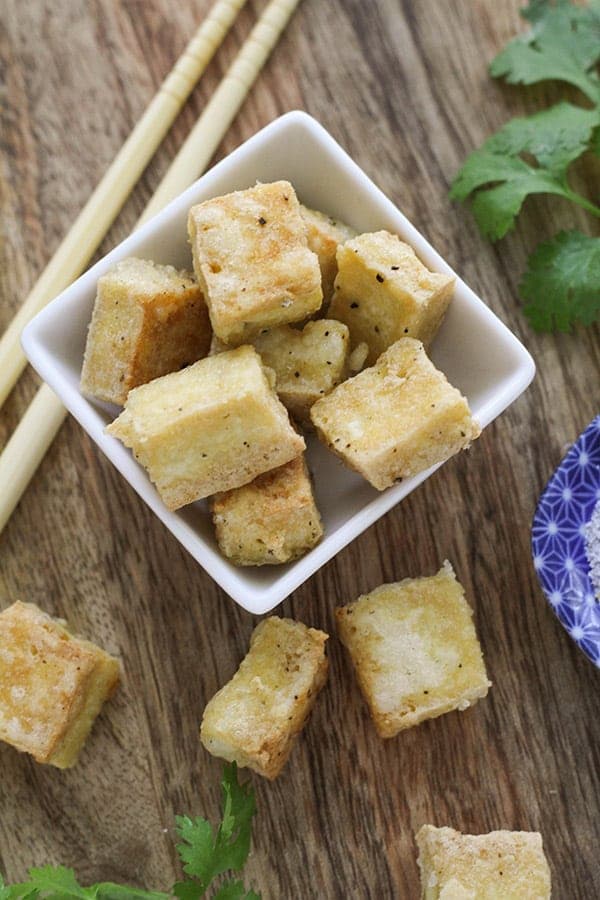 salt and pepper tofu bites in a square bowl. 