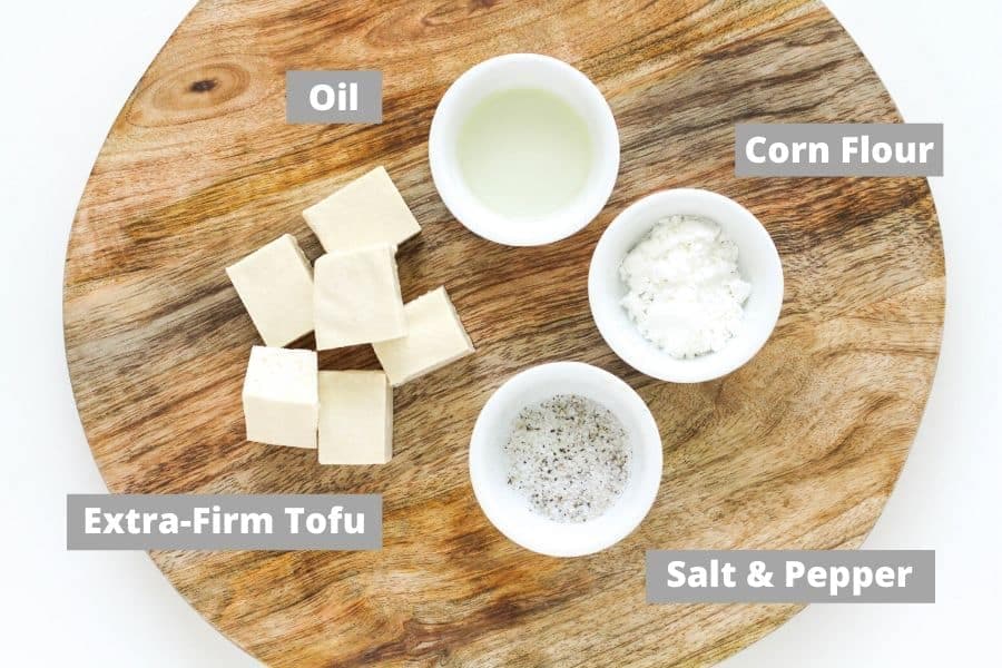 ingredients for salt and pepper tofu on a wooden board.