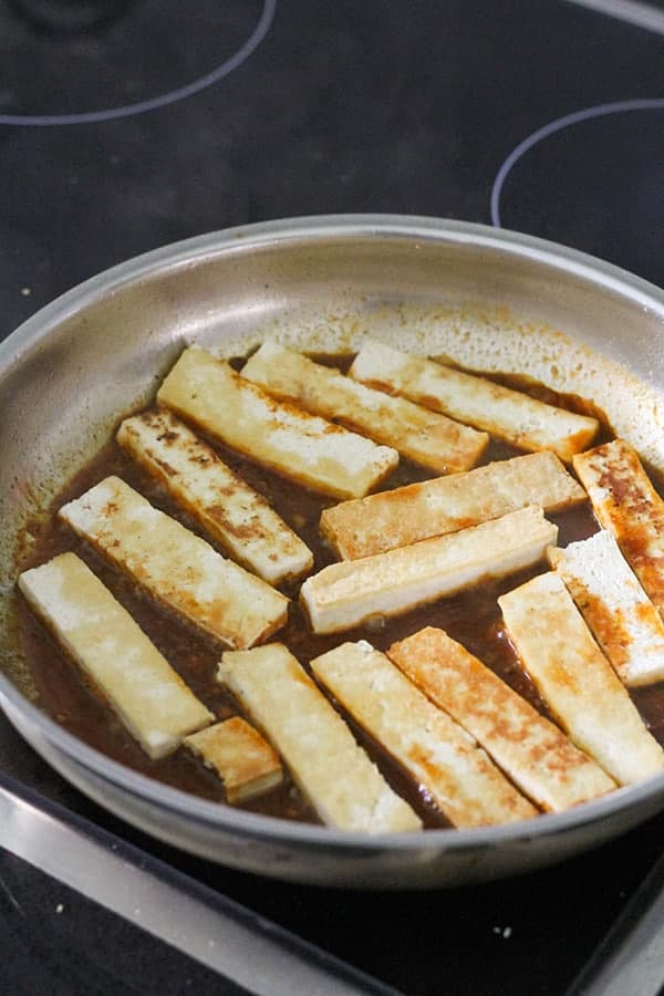 cooked tofu slices in a frying pan.