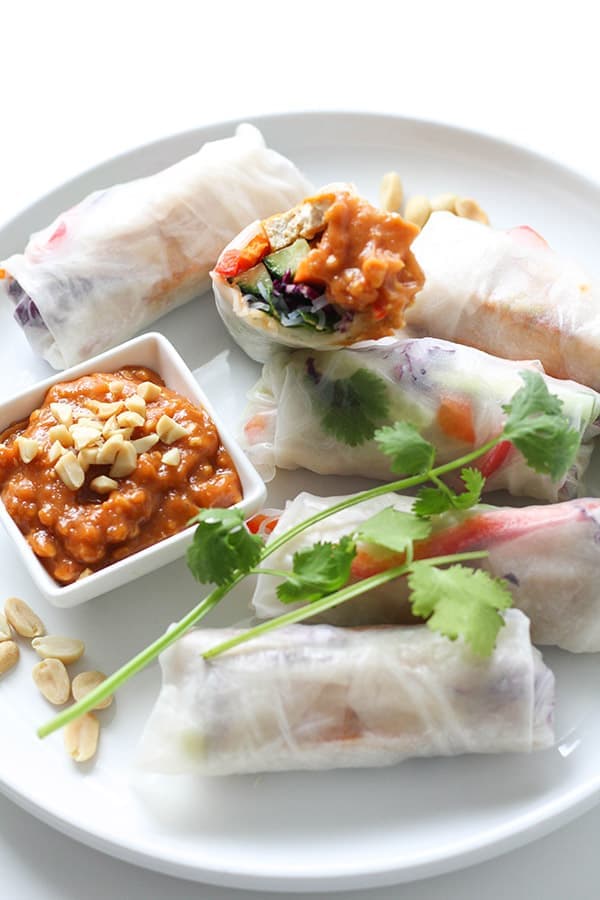 a white plate filled with rice paper rolls.
