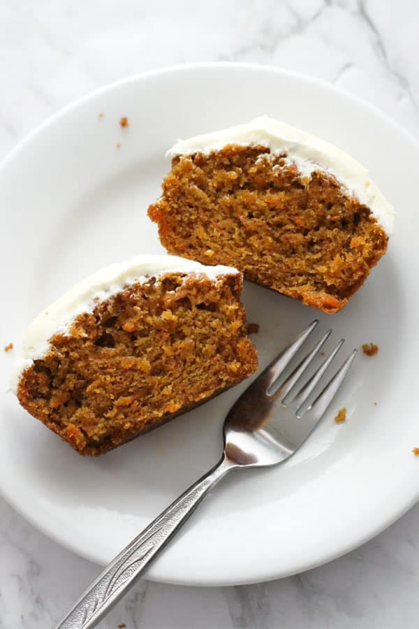 a cupcake cut in half on a white plate.