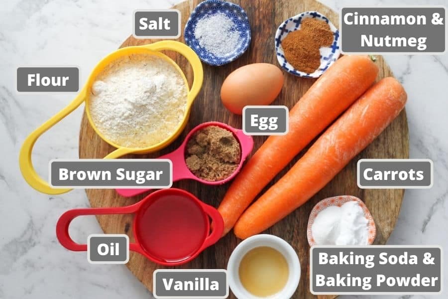 ingredients for carrot cupcakes on a wooden board.