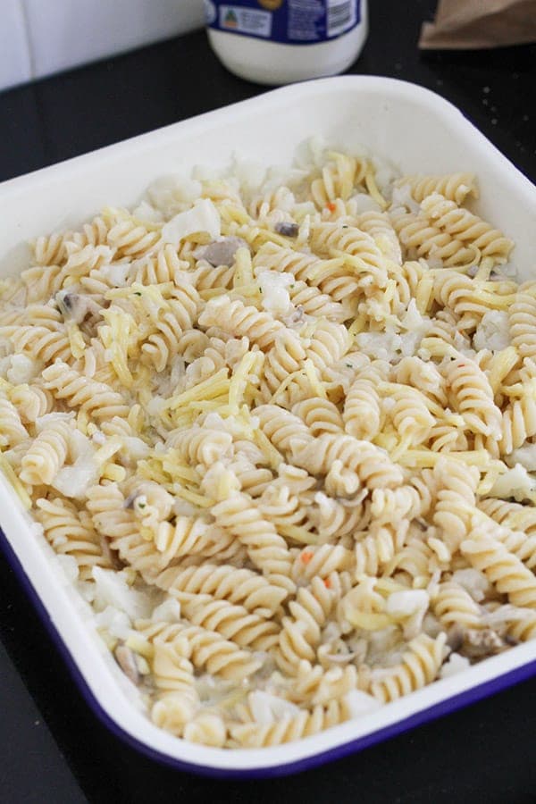 pasta, mushrooms, cauliflower and onion in a baking dish.