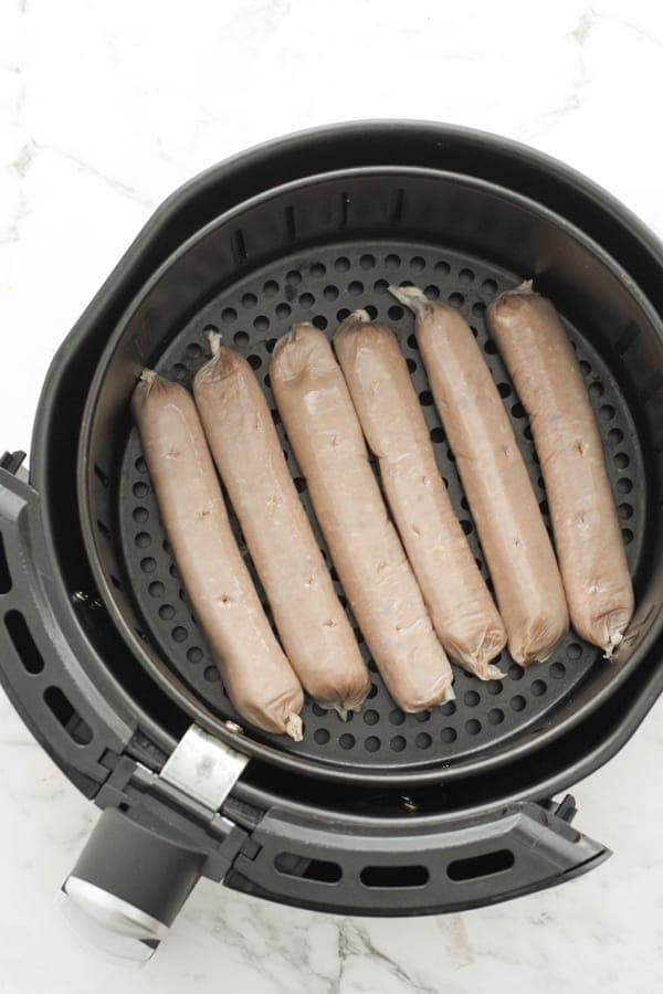 sausages in air fryer basket.
