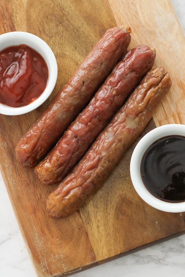 sausages on a wooden serving board.