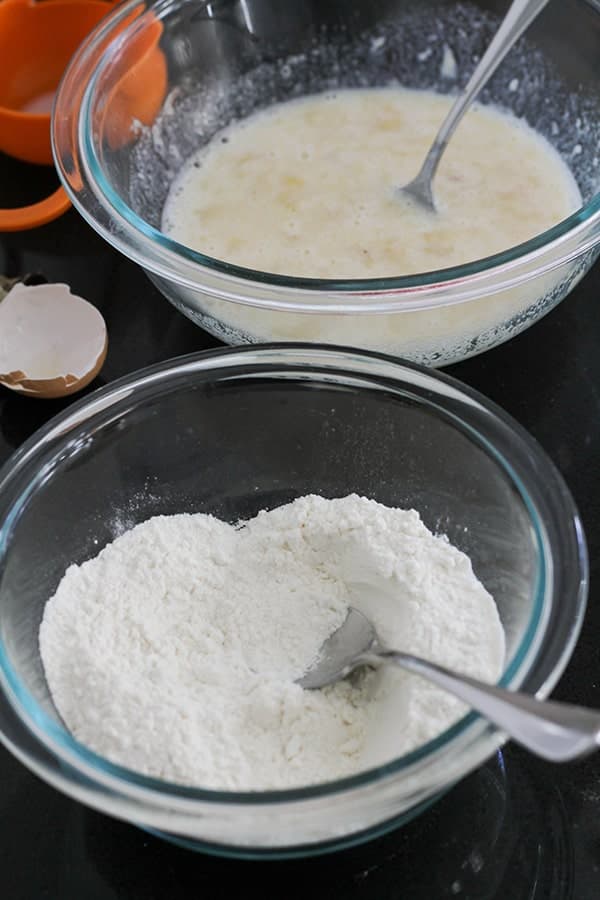 two glass bowls on a bench top filled with ingredients.