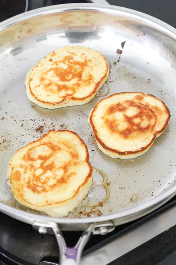 pikelets cooking in a frying pan.