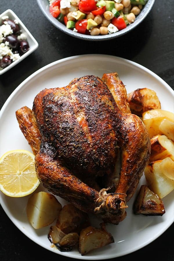 greek roast chicken and potatoes on a white plate.