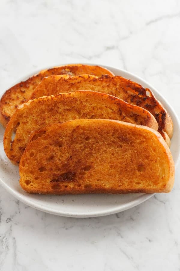 slices of cheese toast on a white plate.