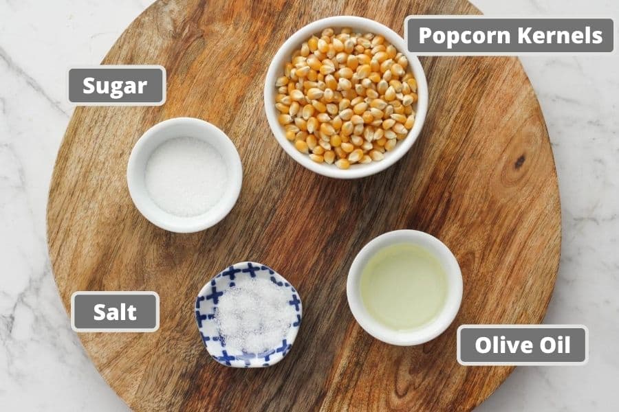 sweet and salty popcorn ingredients on a wooden board.