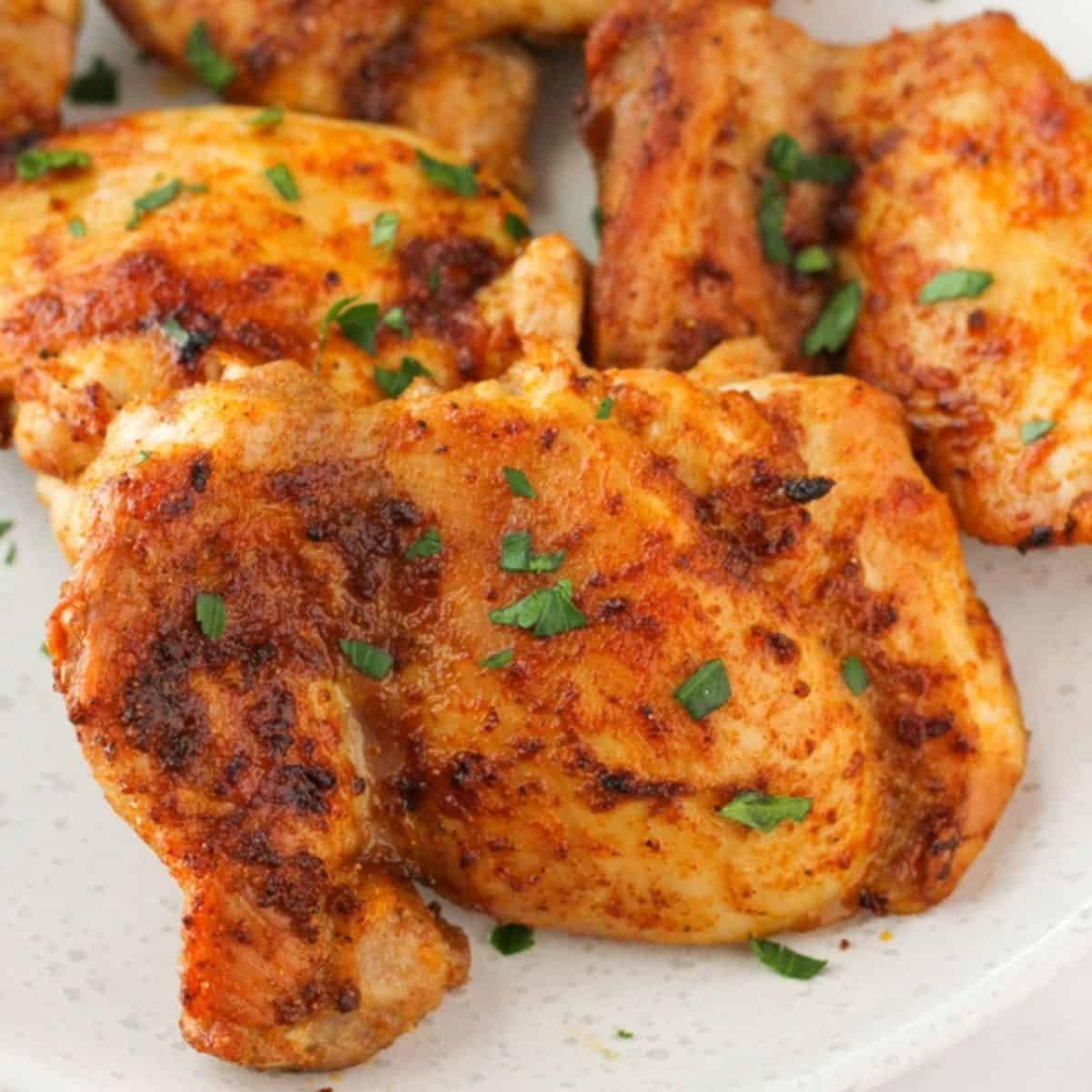 chicken thighs on a plate with parsley.