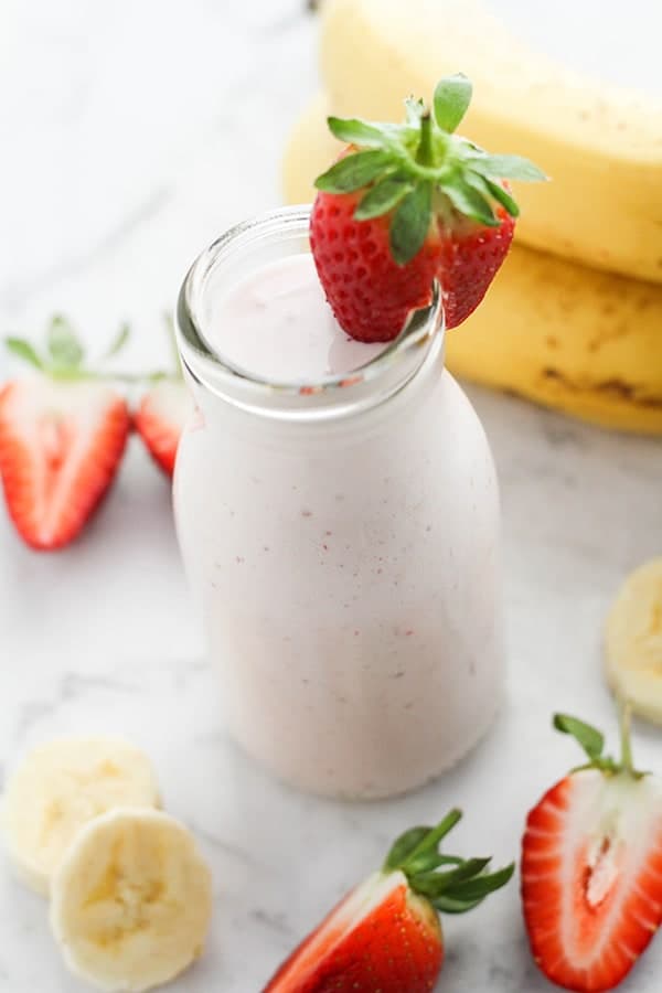 smoothie in a small bottle topped with a strawberry.