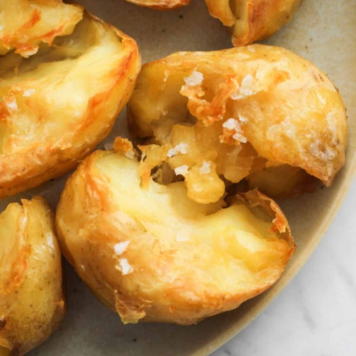 a plate of potatoes with salt flakes on top.