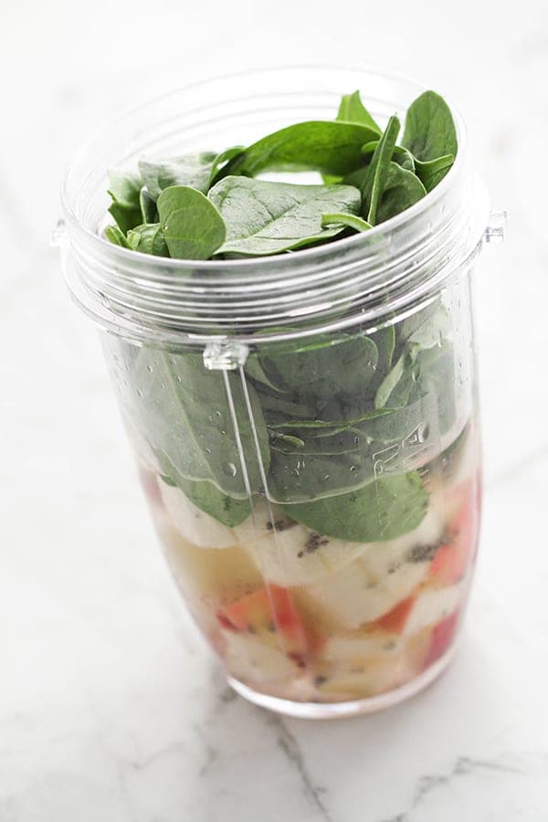 spinach apple smoothie ingredients in a blender cup.