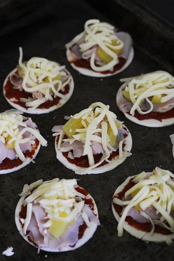 puff pastry topped with pizza toppings on a baking tray.