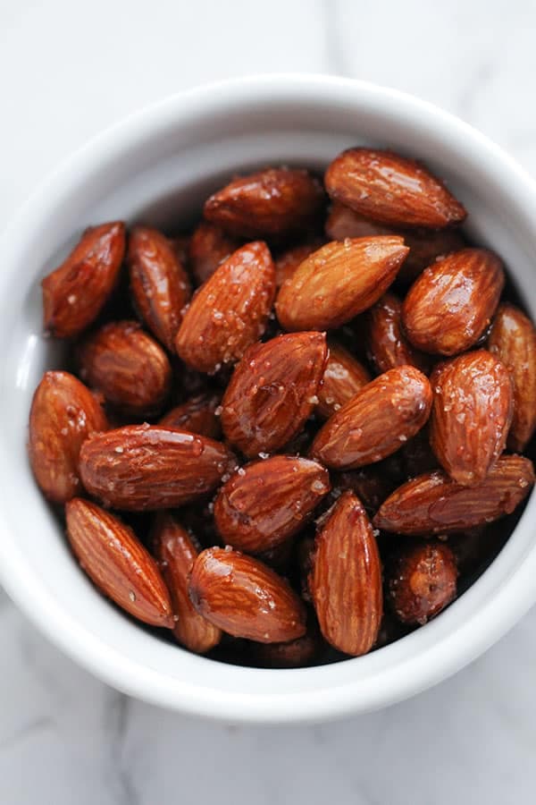 honey roasted almonds in a white bowl.