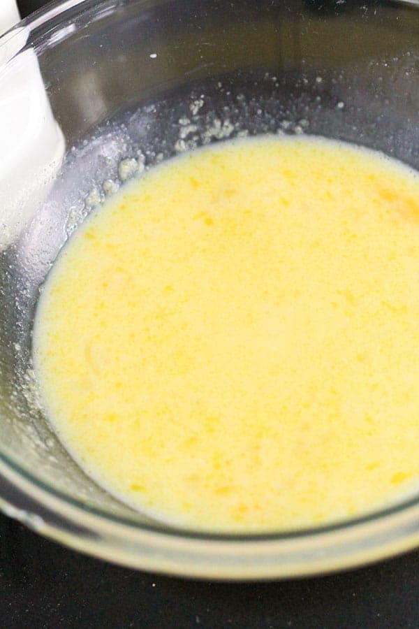 butter, eggs, milk and sugar mixture together in a bowl.