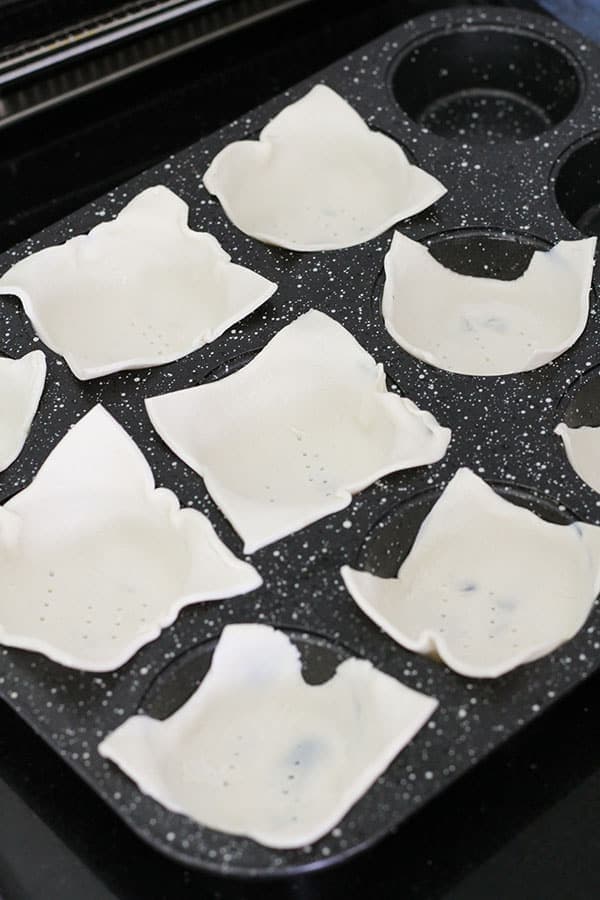 puff pastry pieces in a muffin tray.