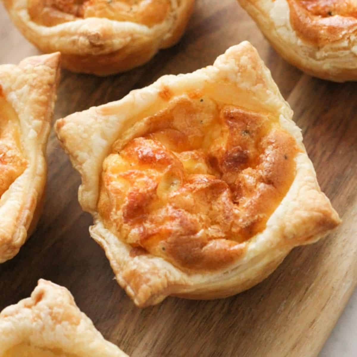 mini quiches on a wooden board.