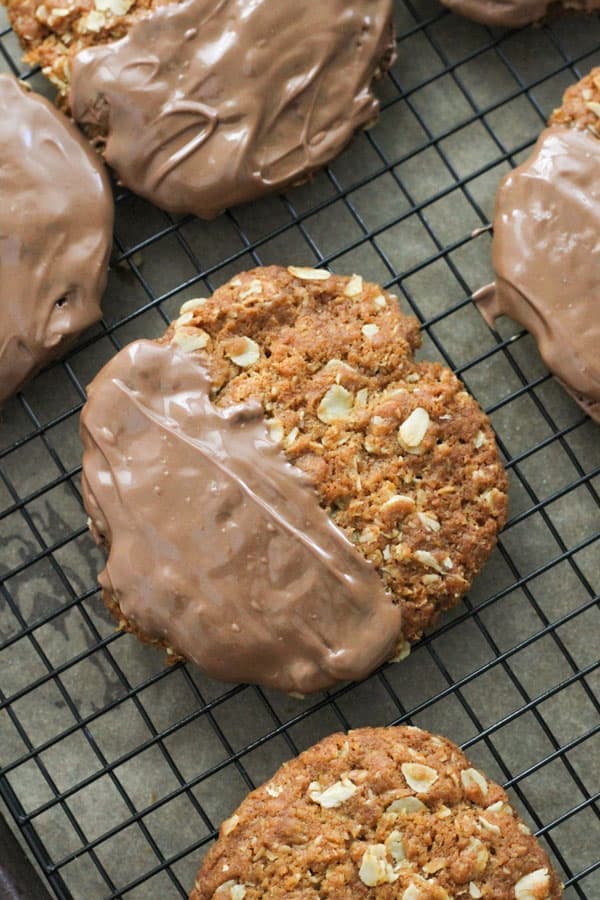 chocolate anzac biscuits on a wire rack. 