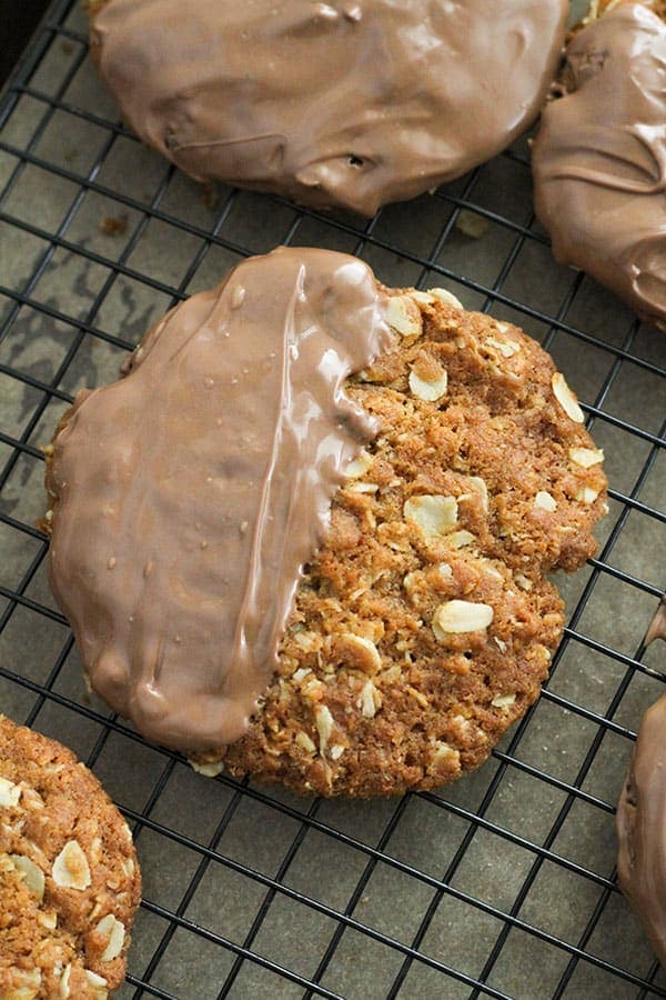 chocolate anzac biscuits on a wire rack.