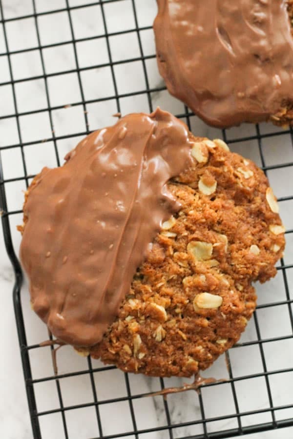 chocolate anzac biscuits on a wire rack.