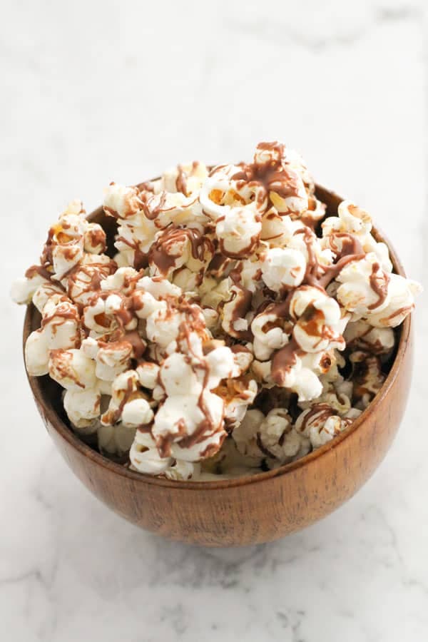 chocolate drizzled popcorn in a bowl.