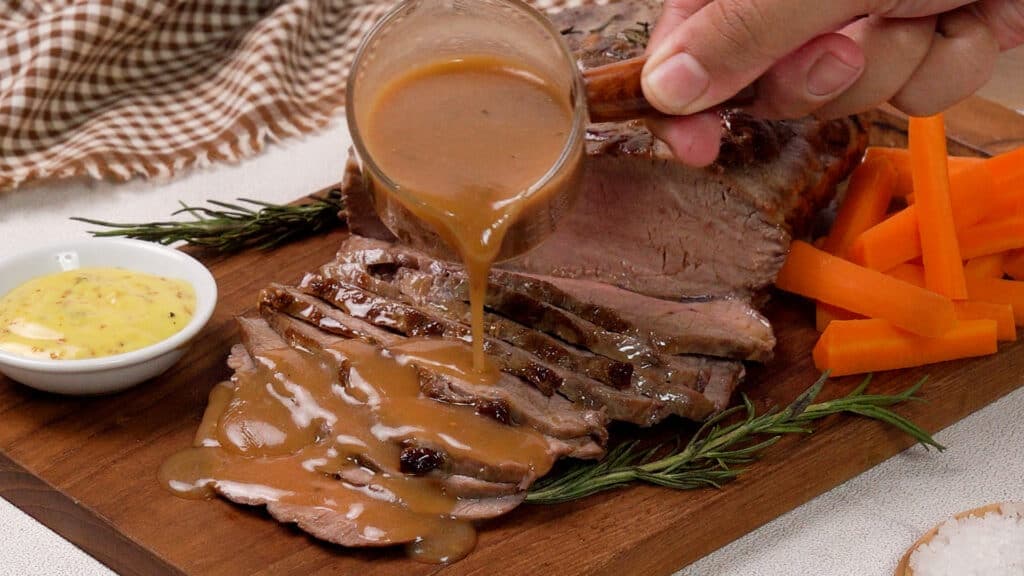 Air Fryer Roast Beef on a wooden coaster poured with gravy