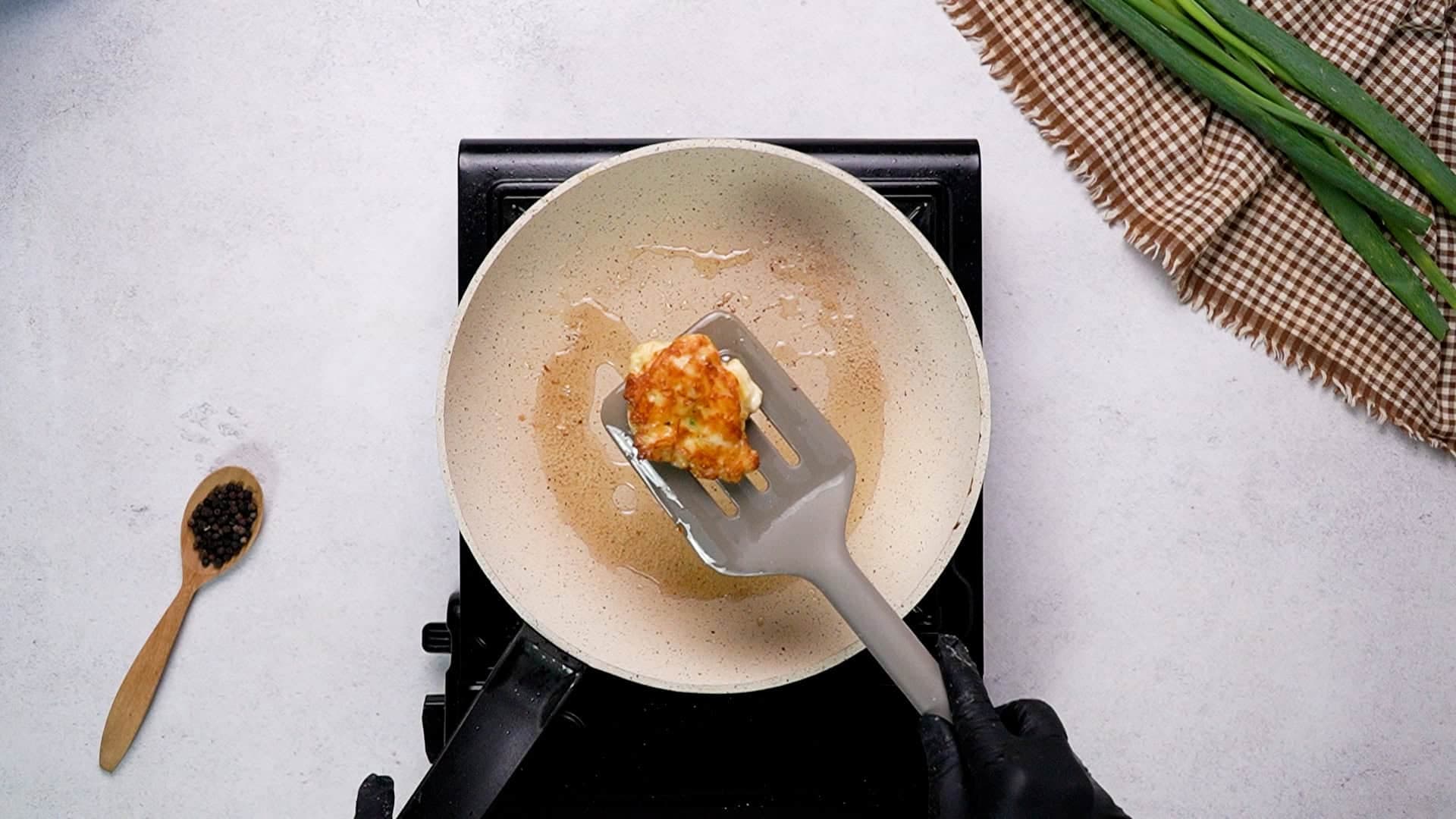 Gently flatten the tops with the back of a spoon to form patties, which will cook more evenly. Let the fritters sauté uncovered for about 3 minutes on the first side until golden brown, then flip them and cook for another 3 minutes or until fully cooked through. Repeat this process with the remaining mixture.