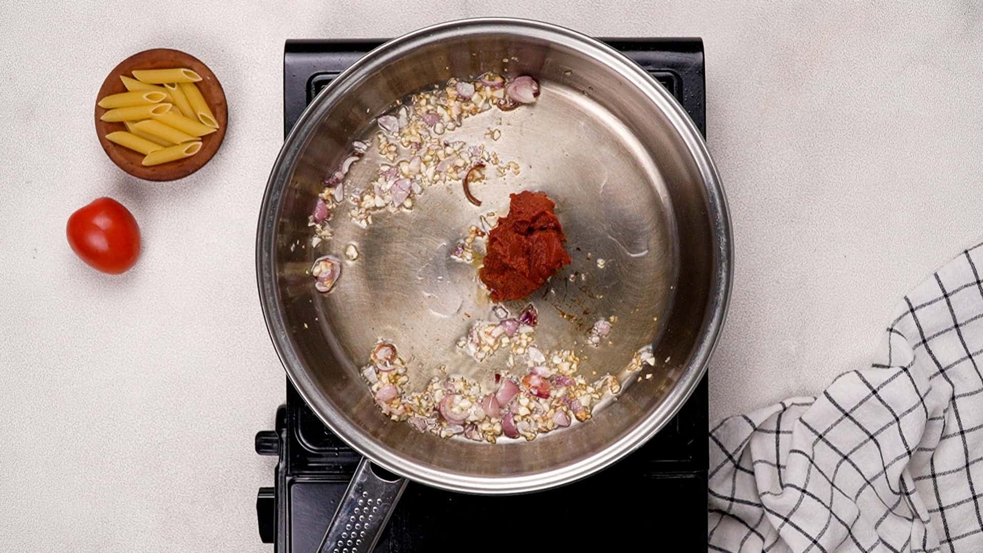 Next, add tomato paste and cook for a minute. If you're using vodka, now's the time to pour it in.<br/>