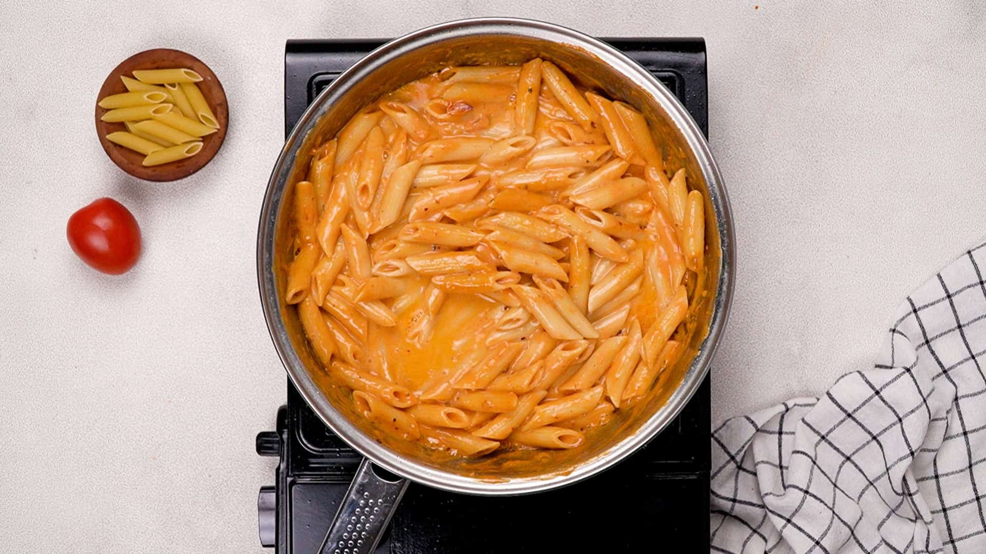 Once the pasta is drained, toss it directly into the frying pan with the spicy vodka sauce, making sure it's well coated. Gradually add the reserved cup of pasta water, stirring as you go.<br/>