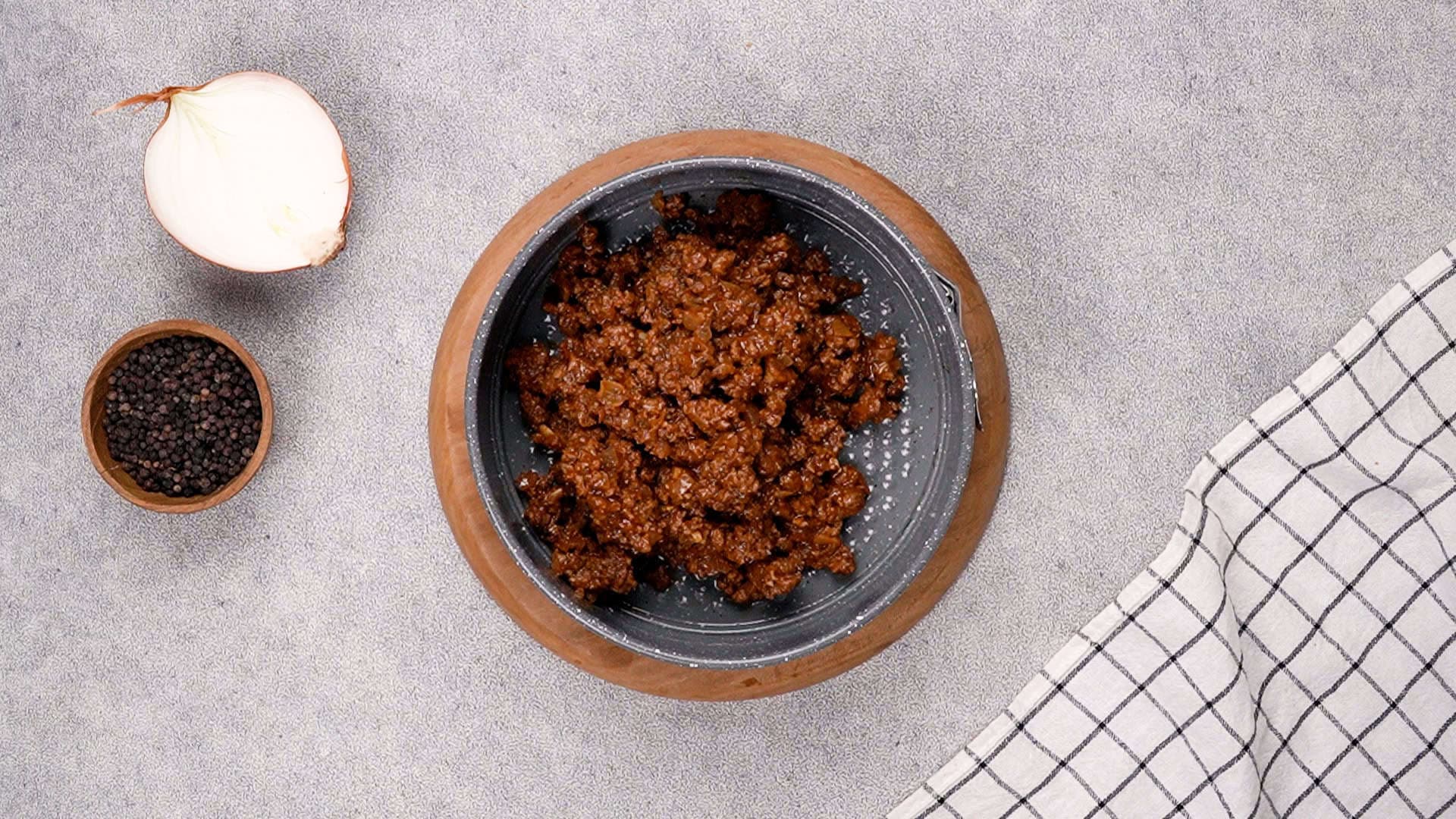 Transfer the beef mixture to the prepared baking dish, spreading it evenly across the bottom.