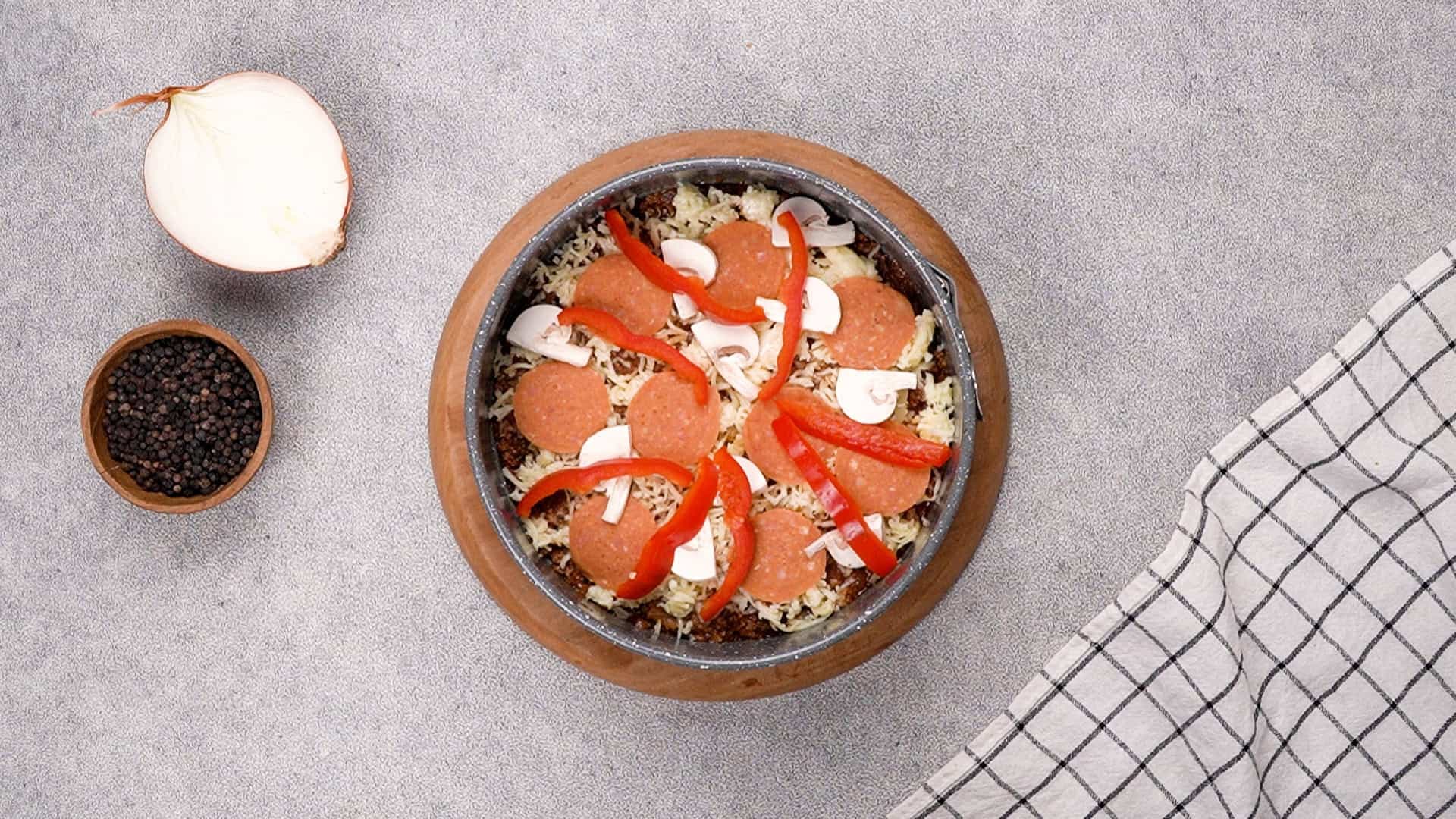Sprinkle the shredded mozzarella cheese over the top evenly, followed by my chosen toppings—sliced pepperoni, mushrooms, and red bell pepper.