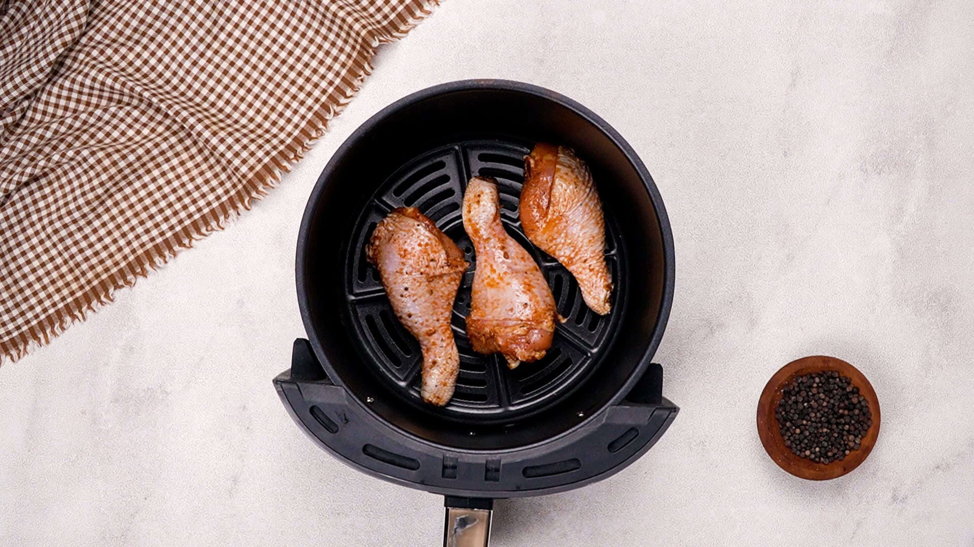 Arrange the drumsticks in a single layer inside the preheated air fryer basket to avoid overcrowding.