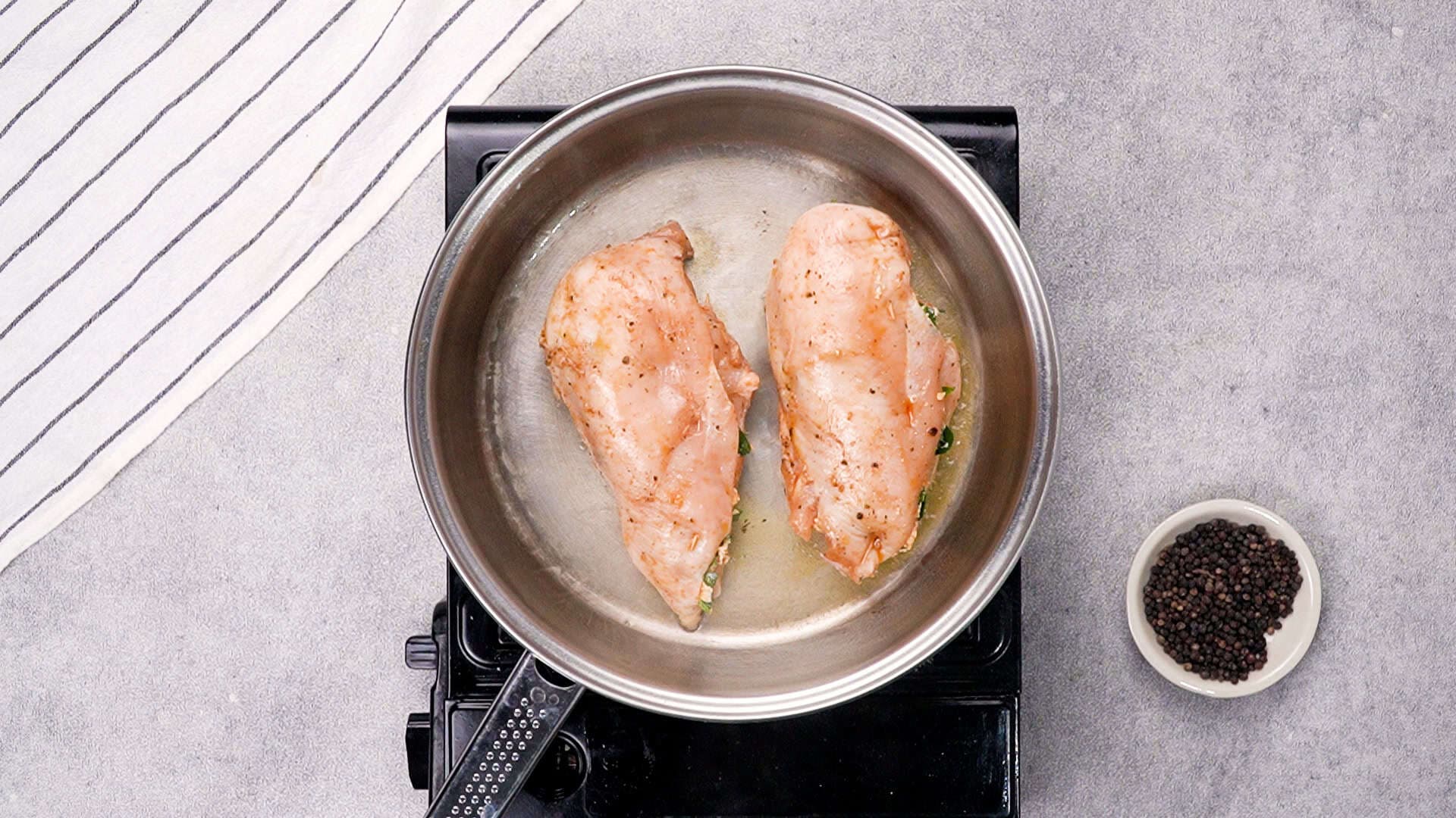 Heat a skillet over medium-high heat and add the butter. Once melted and hot, place the stuffed chicken breasts in the skillet. Sear on all sides until golden brown.