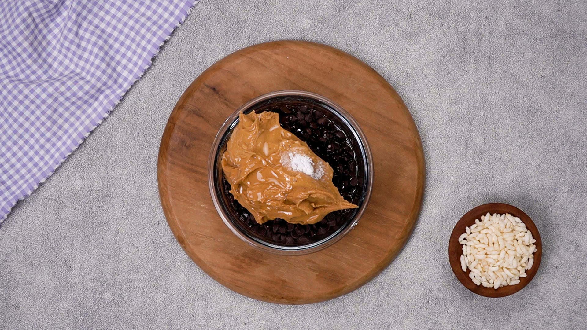 Next, melt the chocolate mix. In a microwave‑safe bowl, add chocolate chips, crunchy peanut butter, coconut oil, and salt.